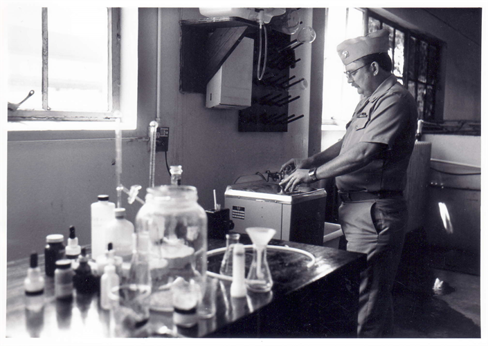 Officer in uniform performing water quality test in a laboratory