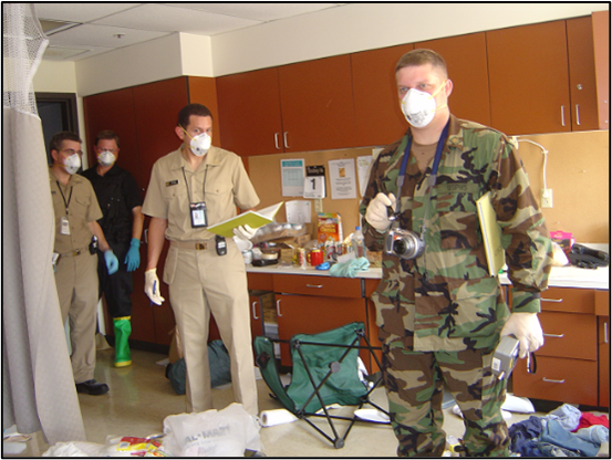 Three officers in uniform and N-95 respirators indoors conducting an evaluation